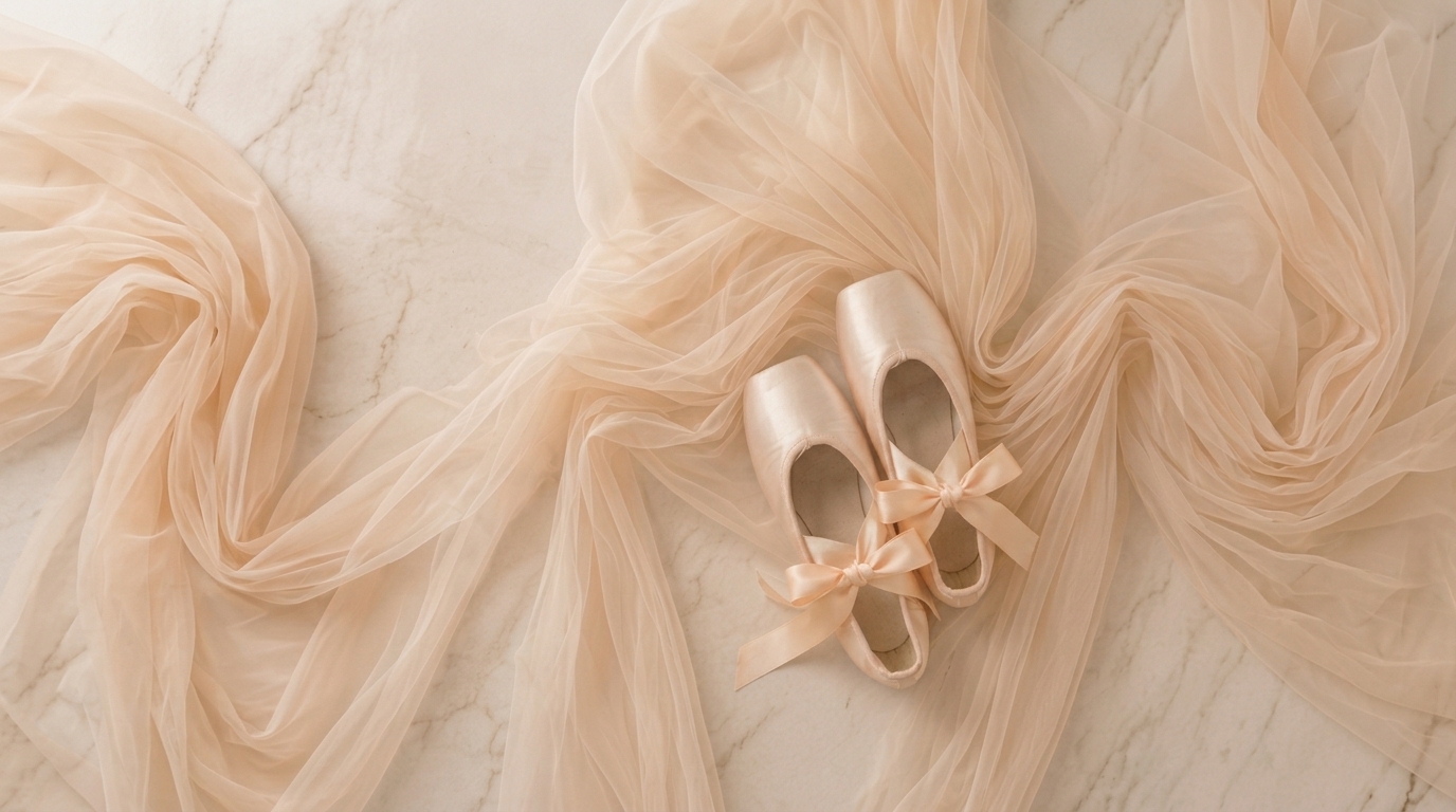 Ballet pointe shoes with flowing tulle ribbons on a soft marble surface